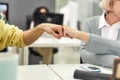 Cropped shot of aged woman, senior intern doing a fist bump, Friendly worker cheering new employee while working in the