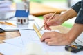 Cropped shot of architect man using pencil and ruler, working on plans at his workplace Royalty Free Stock Photo