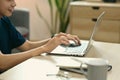 Cropped shot of asian man sitting in cozy living room and surfing internet with laptop computer Royalty Free Stock Photo