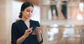 Technology helps her manage her busy schedule. Cropped shot of an attractive young businesswoman using a smartphone Royalty Free Stock Photo