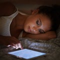 Nocturnal networking. Cropped shot of an attractive young woman using her tablet in bed. Royalty Free Stock Photo