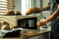 Cropped shot of baker taking freshly baked bread from the oven. Healthy eating, traditional bakery and pastry concept Royalty Free Stock Photo