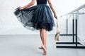 cropped shot of ballerina in black tutu holding pointe shoes in ballet studio Royalty Free Stock Photo