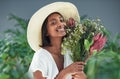 Give me flowers and Ill be the happiest person. Cropped shot of a beautiful young woman smelling a bouquet of flowers.