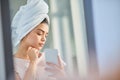 Using her phone to get a better angle. Cropped shot of a beautiful young woman using her cellphone to check her skin in Royalty Free Stock Photo