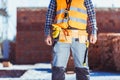 Cropped shot of builder in reflective vest and toolbelt standing Royalty Free Stock Photo