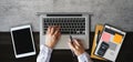 Cropped shot of business worker hands holding smartphone, tablet and laptop on modern office desk with office supplies top view Royalty Free Stock Photo