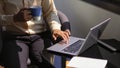 Businessman hand using laptop and holding coffee cup while working at portable workspace Royalty Free Stock Photo