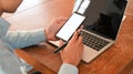 Cropped shot of businessman holding white blank smartphone and pen in hand. Royalty Free Stock Photo