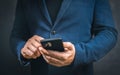 man in suit holding smart phone. Businessman touching screen modern mobile phone. Close-up of businessman using cell phone. dark Royalty Free Stock Photo