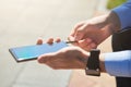 Cropped shot of a businessman using flash drive for smartphone while working outdoors on a sunny day, focus on male