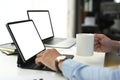 Cropped shot of businessman working on computer tablet while hand holding coffee cup. Royalty Free Stock Photo