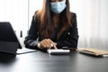 Cropped shot of accountant in protective mask using calculator and laptop for calculating finance at office desk. Royalty Free Stock Photo