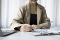 Businesswoman holding pen and checking financial reports on white office desk. Royalty Free Stock Photo