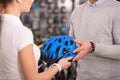 cropped shot of buyer and seller holding bicycle helmet