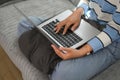 Cropped shot casual young woman browsing internet on laptop at home Royalty Free Stock Photo