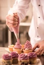 cropped shot of confectioner putting cream