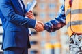 Cropped shot of construction worker in reflective vest shaking hands Royalty Free Stock Photo