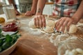 Cropped shot of couple making pizza together. Woman in apron kneading the dough while man helping her in the kitchen Royalty Free Stock Photo