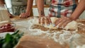 Cropped shot of couple making pizza together. Woman in apron kneading the dough while man helping her in the kitchen Royalty Free Stock Photo