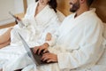 Cropped Shot Of Couple Using Tablet And Laptop In Bedroom Royalty Free Stock Photo