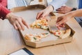 cropped shot of coworkers eating pizza