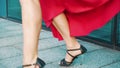 Cropped shot of dancing blonde woman in red dress in urban environment