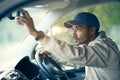 Off to make his next delivery stop. Cropped shot of a delivery man adjusting the rear-view mirror of his van. Royalty Free Stock Photo