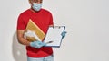 Cropped shot of delivery man wearing face mask and protective gloves holding parcels and envelopes, showing form for Royalty Free Stock Photo