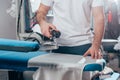 cropped shot of dry cleaning worker using industrial iron