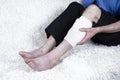 Cropped shot of elderly man sitting on sofa and suffering from leg pain. Leg with bandage. Royalty Free Stock Photo