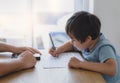 Cropped shot father helping his boy with homework, Dad and Son using mobile phone doing homework together, Teacher teaching little Royalty Free Stock Photo