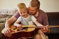 Time for another guitar lesson with Dad. Cropped shot of a father and his little son playing the guitar together at home Royalty Free Stock Photo