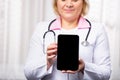 Cropped shot of a female doctor using a digital tablet, showing mock up empty screen to the camera. Selective focus on digital Royalty Free Stock Photo