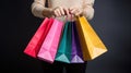 Cropped shot of female hand holding bunch of different colorful blank shopping bags over isolated black background. AI Generative Royalty Free Stock Photo
