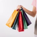 Cropped shot of female hand holding bunch of different colorful blank shopping bags over isolated white background. AI Generative Royalty Free Stock Photo