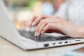 Cropped shot of female hands with nice manicure keyboards on laptop computer, works from home, sits at table and searches internet Royalty Free Stock Photo