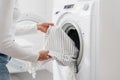 Woman load dirty clothes in washing machine indoors Royalty Free Stock Photo