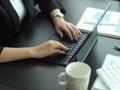 Female hands typing on tablet keyboard on the table with business document and mug Royalty Free Stock Photo