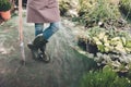 Gardener in rubber boots and apron with spade in garden