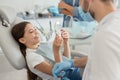 Cropped shot of girl looking in the mirror after dental procedure while mother standing near her for support