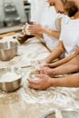 cropped shot of group of baking manufacture workers kneading