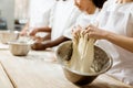 cropped shot of group of baking manufacture workers kneading dough