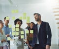 Theyve got a plan of action. Cropped shot of a group of businesspeople working on a glass wall in the office. Royalty Free Stock Photo