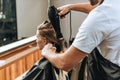 Cropped shot of hairdresser drying hair to attractive young woman Royalty Free Stock Photo