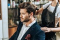 Cropped shot of hairstylist combing hair to handsome young man