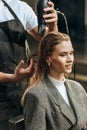 Cropped shot of hairstylist drying hair to beautiful smiling girl