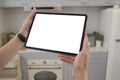 Cropped shot of hand holding blank screen of tablet at home in kitchen. Royalty Free Stock Photo