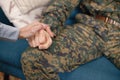 Cropped Shot Of A Hands Of Young Soldier Sitting On A Sofa And Woman