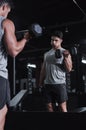 Making sure his form is on point. Cropped shot of a handsome and athletic young man working out with dumbbells in the Royalty Free Stock Photo